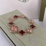 Van Cleef & Arpels watch with a rose gold dial featuring red mother-of-pearl clover motifs.